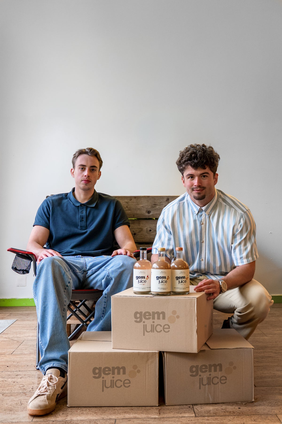 The Gem Juice team with bottles of Apple, Original and Mint on stacked Gem Juice boxes
